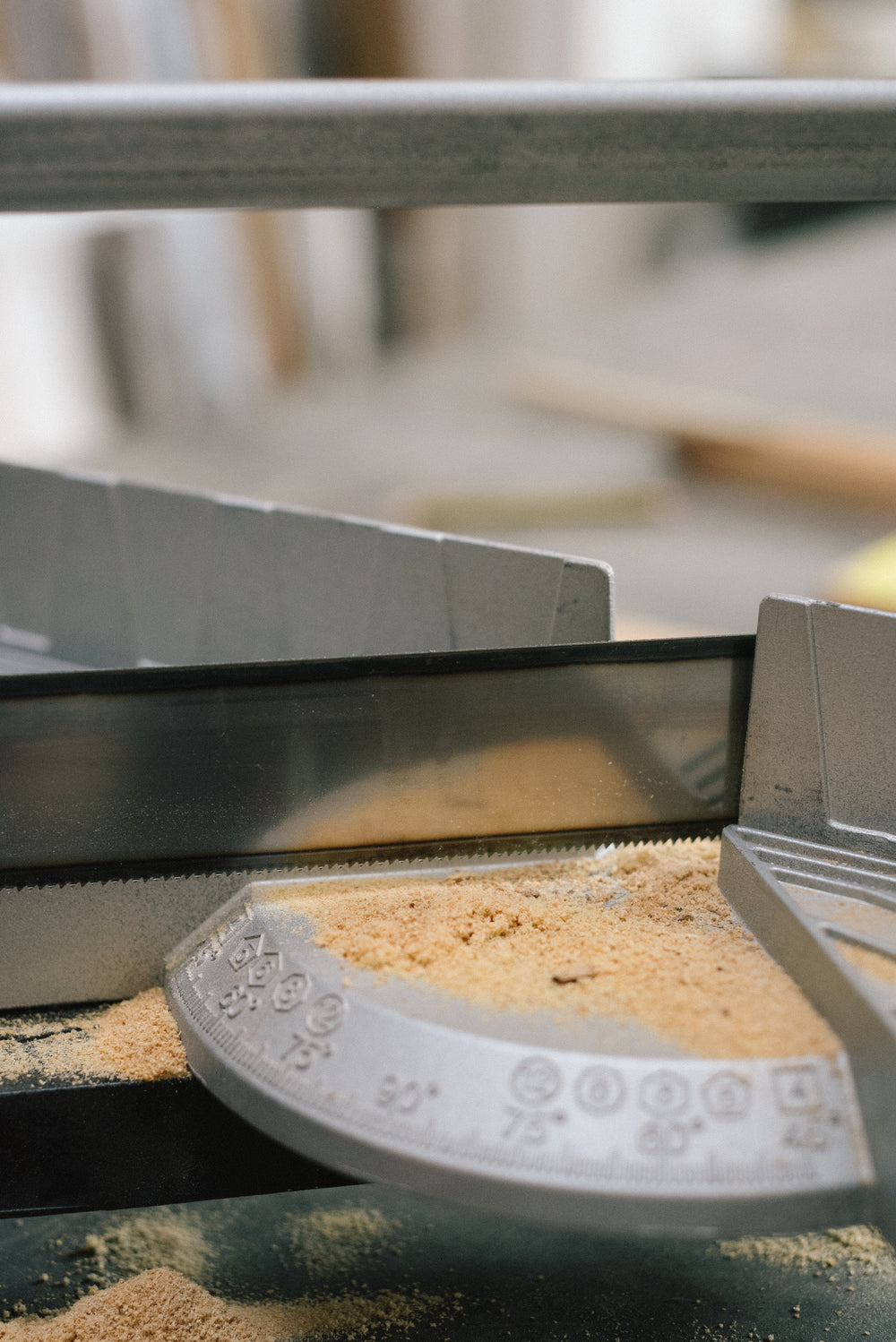 Nahaufnahme einer präzisen Gehrungssäge mit Holzspänen in der Werkstatt von Frameworks Berlin.